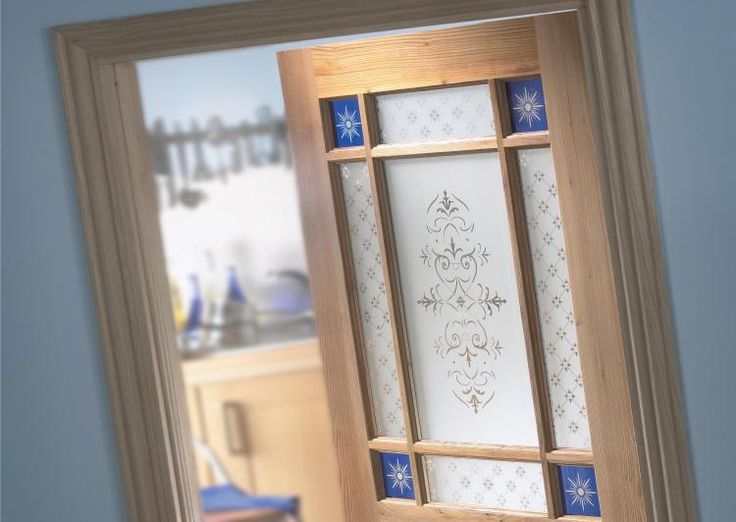 an open door with blue and white designs on the glass is seen through a mirror