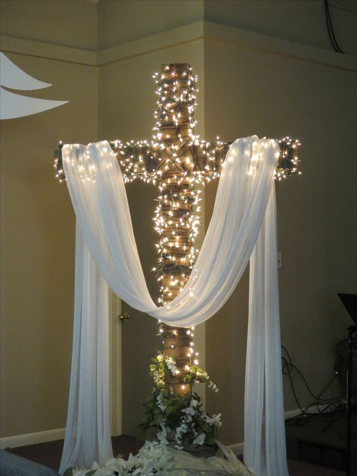 a cross decorated with lights and flowers