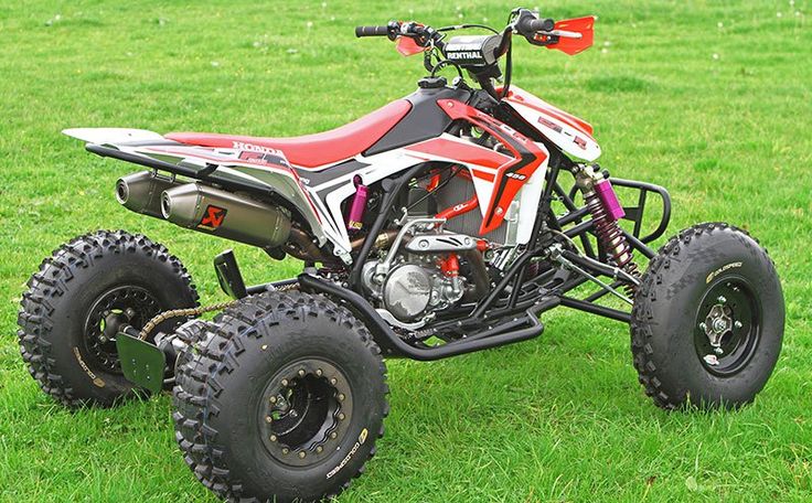 a red and white four wheeler on some grass