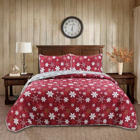 a red and white comforter set with snowflakes on it in front of a clock