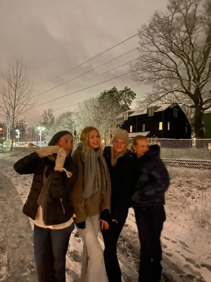 three women are standing in the snow together