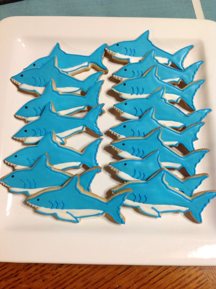 there are many cookies shaped like sharks on the plate