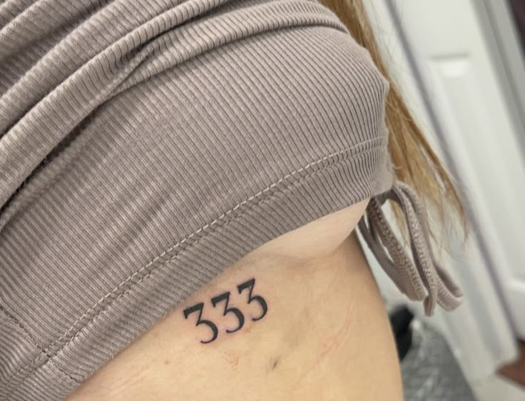 a woman with a small tattoo on her stomach that says 535 in black ink