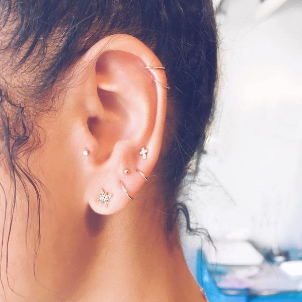 a woman with ear piercings on top of her head