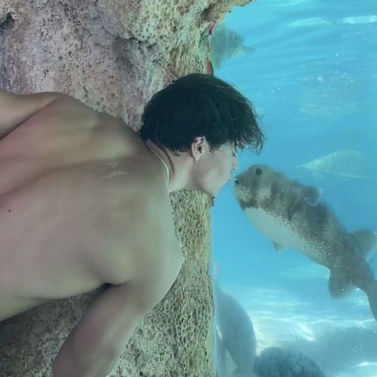 a man standing next to a fish under water