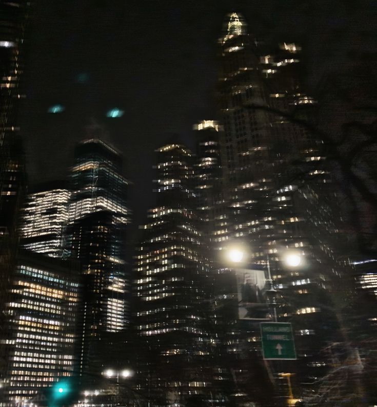 the city is lit up at night with street lights and skyscrapers in the background