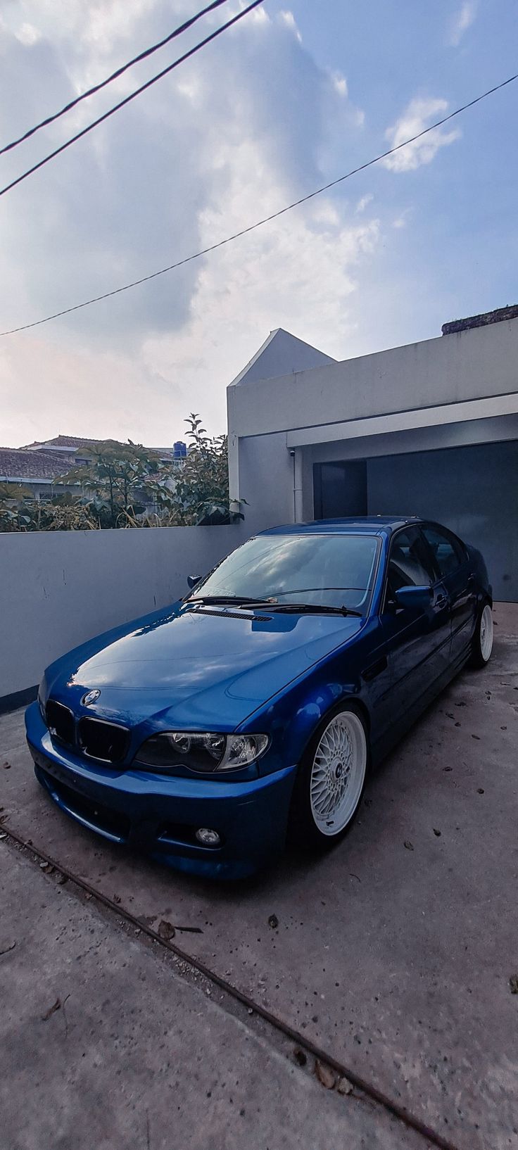 a blue car parked in front of a garage