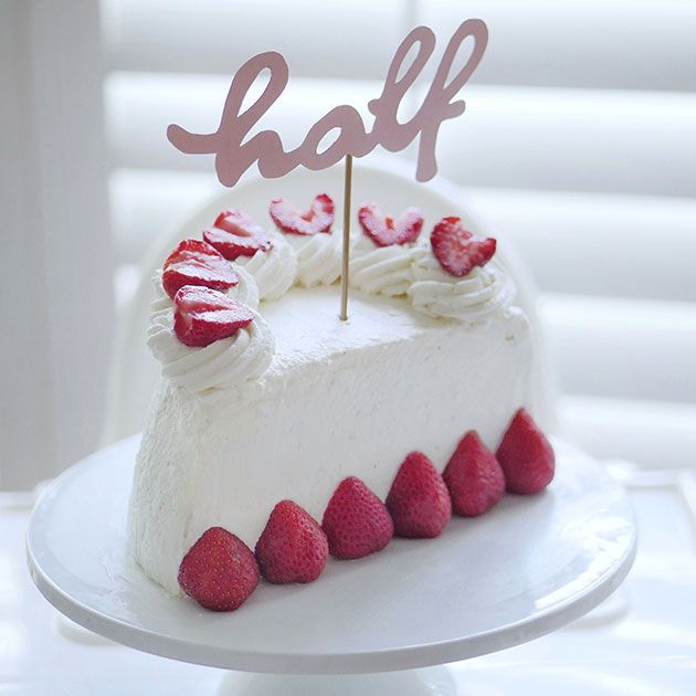 a white cake topped with strawberries and the word half