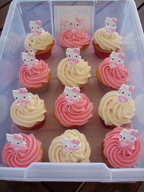 a plastic container filled with cupcakes covered in frosting and hello kitty decorations