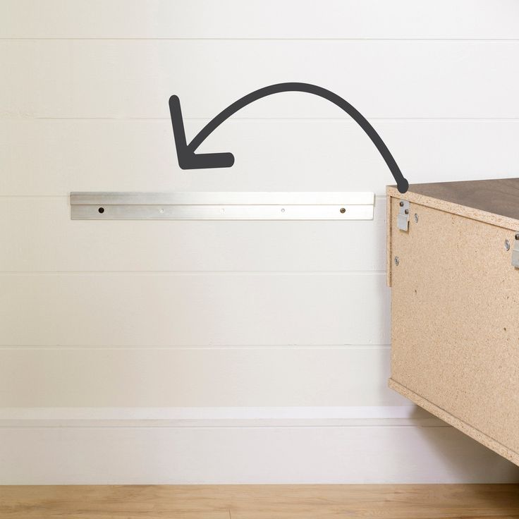 an empty room with a closed drawer and a black arrow drawn on the wall above it