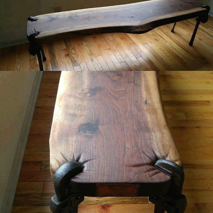 a bench made out of wood with metal legs and arms on it's back