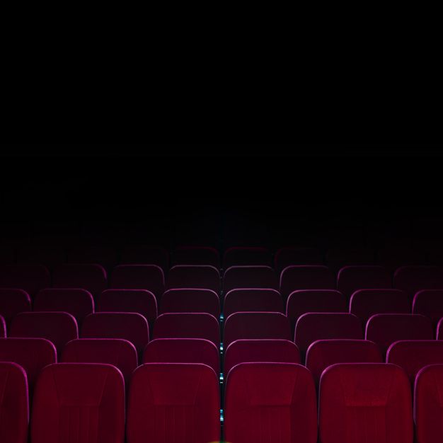 an empty theater with rows of red seats