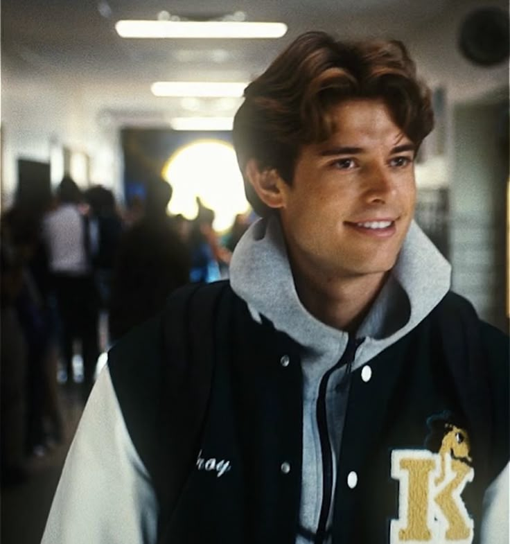 a young man wearing a black and white jacket with the letter k on it's chest