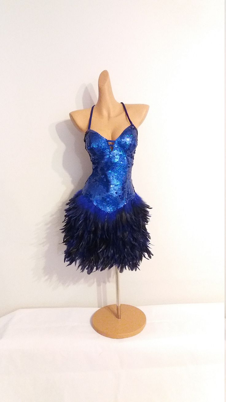 a mannequin wearing a blue dress with feathers on it's head and neck