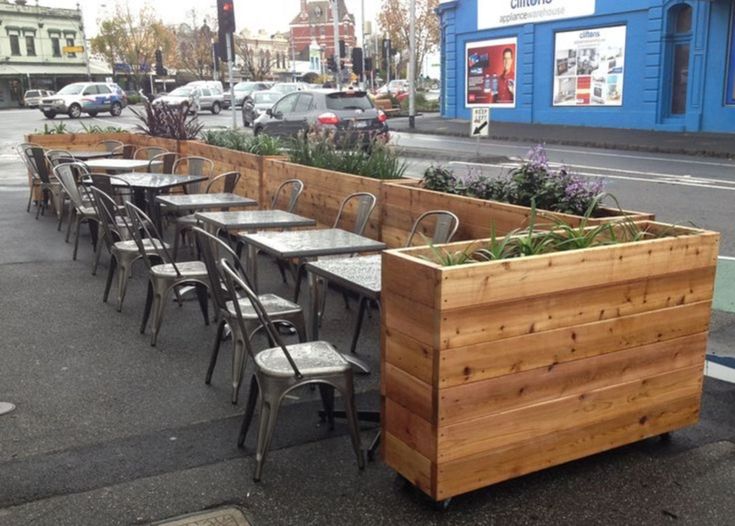 tables and chairs are lined up on the sidewalk