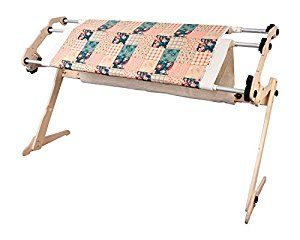 an ironing board with quilts on it and a wooden stand holding the fabric