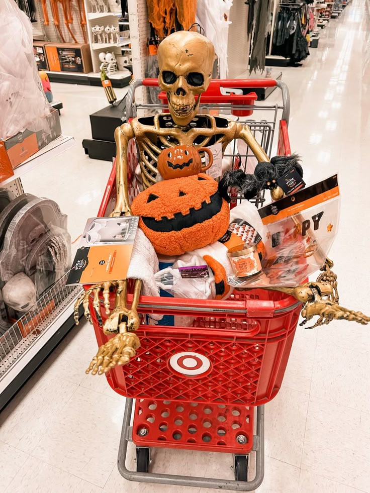 a skeleton sitting on top of a shopping cart in a store filled with halloween items