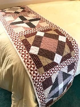 a bed with a quilt on top of it