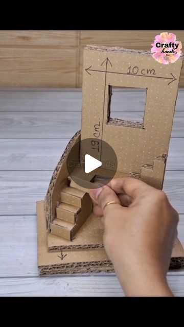 someone is making a cardboard doll house with stairs