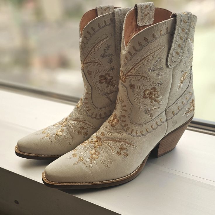 a pair of cowboy boots sitting on top of a window sill