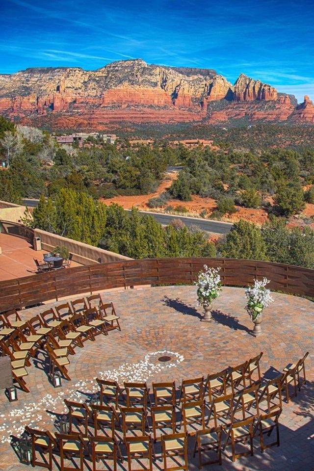 an outdoor seating area with mountains in the background and tables set up for a wedding