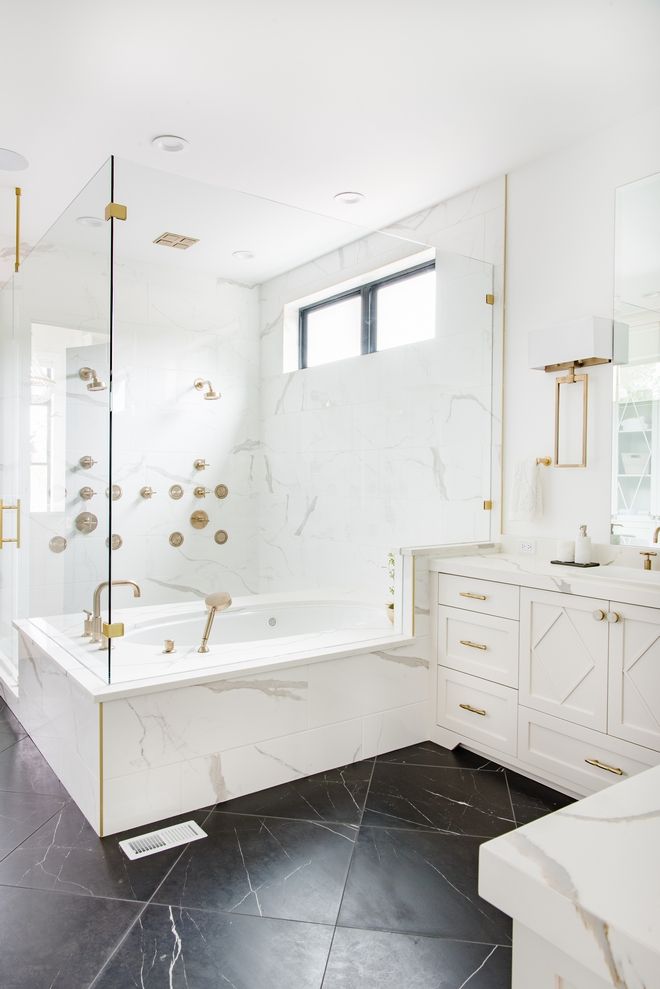 a large bathroom with marble floors and white walls, along with a walk in shower