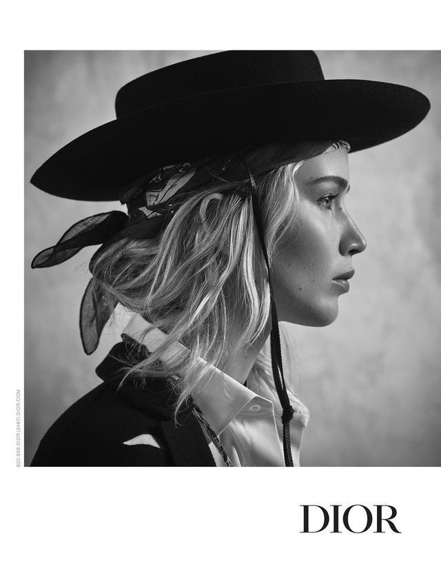 a black and white photo of a woman wearing a hat