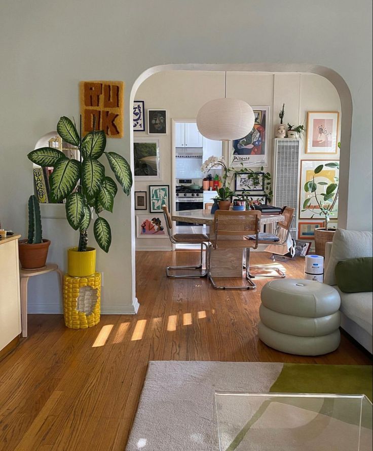 a living room filled with lots of furniture and decor on top of wooden flooring