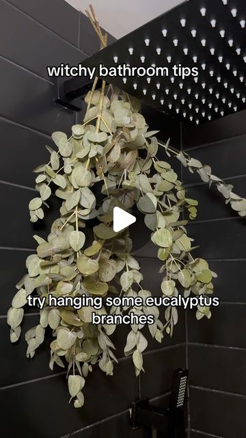 a bathroom with black tile and white tiles on the wall, has a video explaining how to clean it