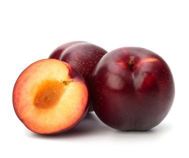 two plums with one cut in half and the other whole, on a white background