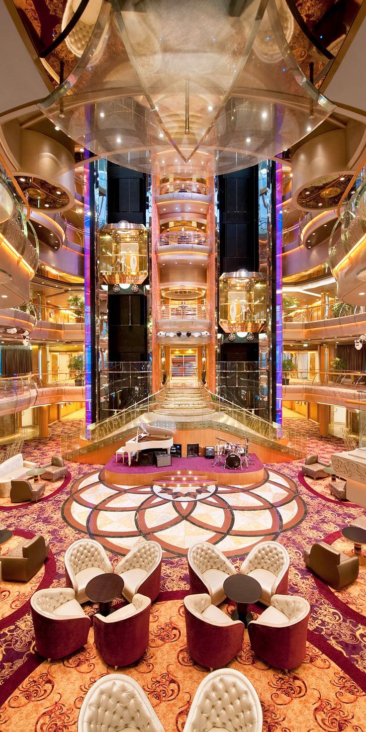 the inside of a large cruise ship with lots of seating and chairs on it's floor