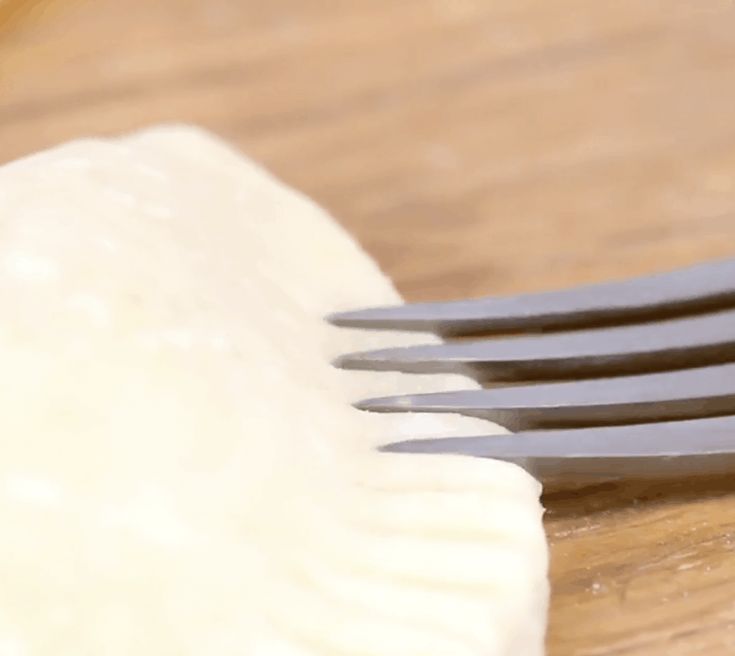 a fork with some food on it sitting on a table