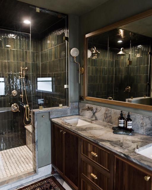 a bathroom with marble counter tops and wooden cabinetry, along with a walk in shower