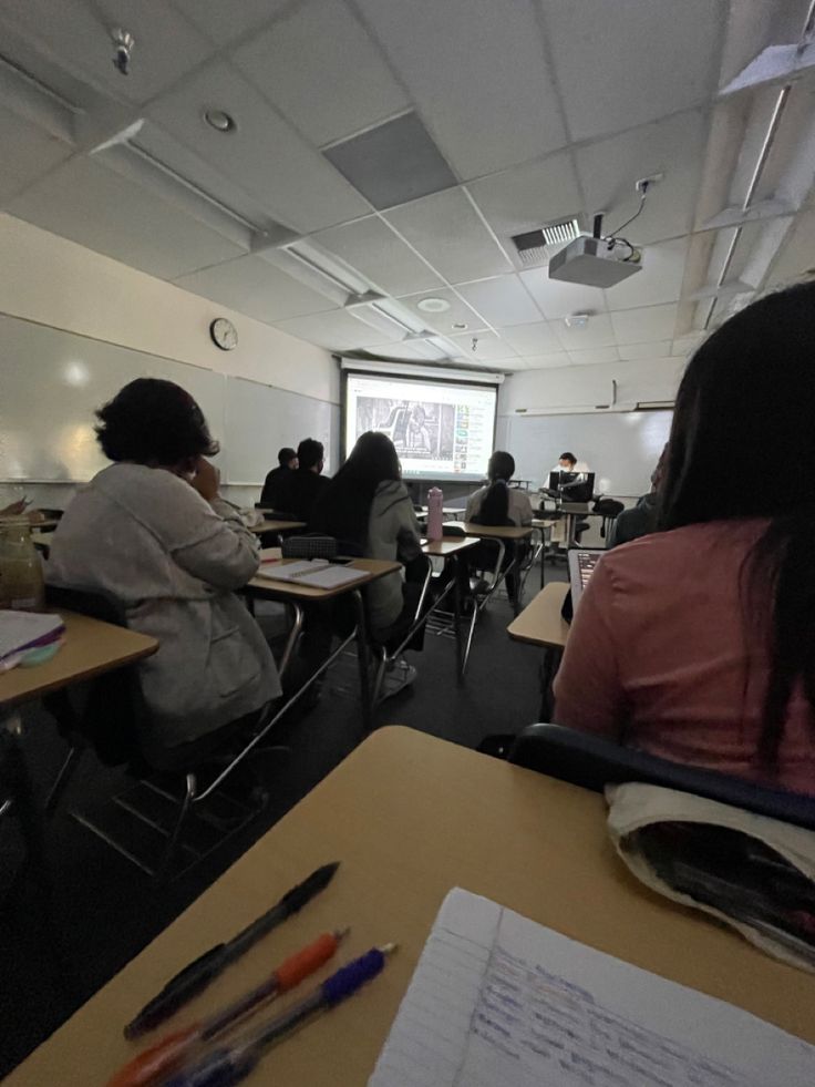 several people sitting at desks in a classroom