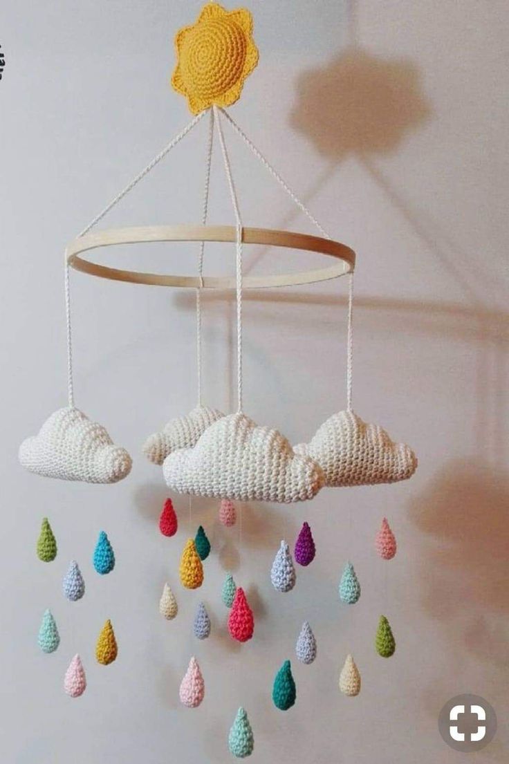 a crocheted mobile with clouds and raindrops hanging from it