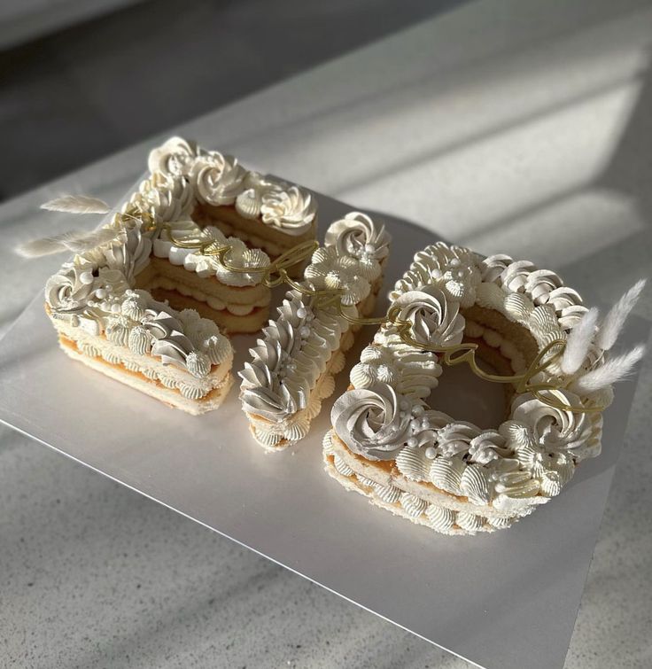 two decorated cookies sitting on top of a white counter next to each other in front of a window