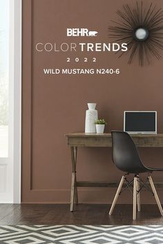 a desk with a laptop on it in front of a wall that says behr color trends 2012