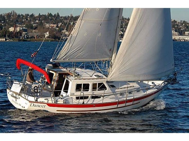 a white sailboat with red trim on the water