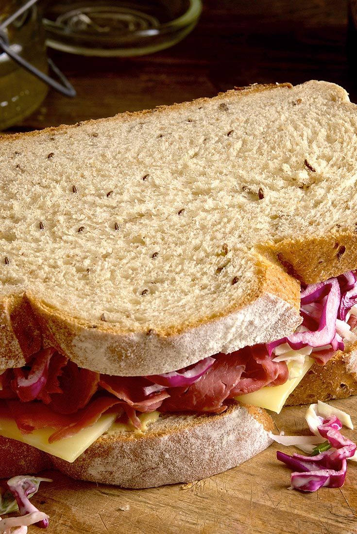 a sandwich with meat, cheese and cole slaw