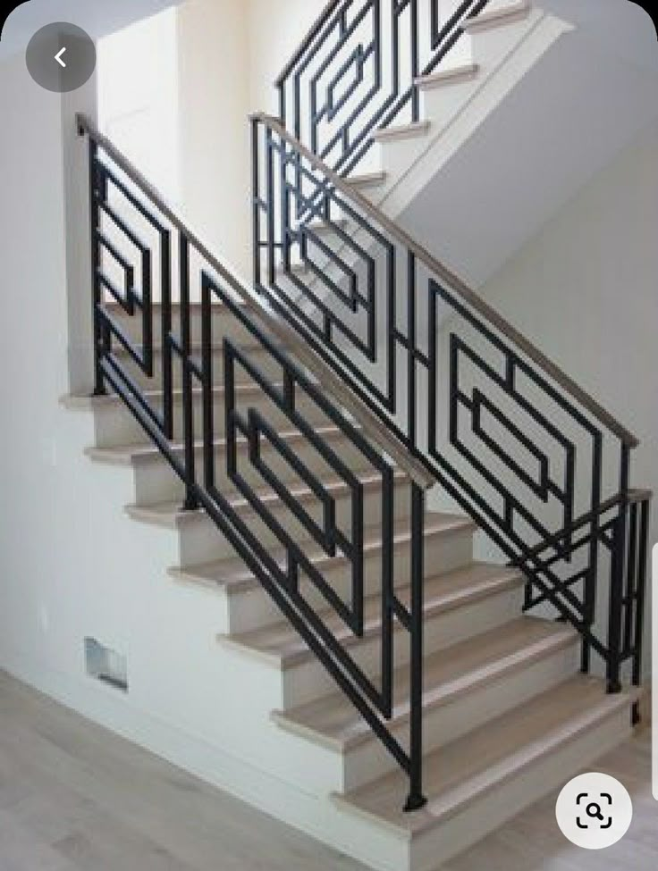 the stairs are made of metal and have geometric designs on each handrail, along with wood flooring