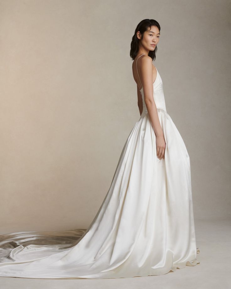 a woman in a white wedding dress posing for the camera