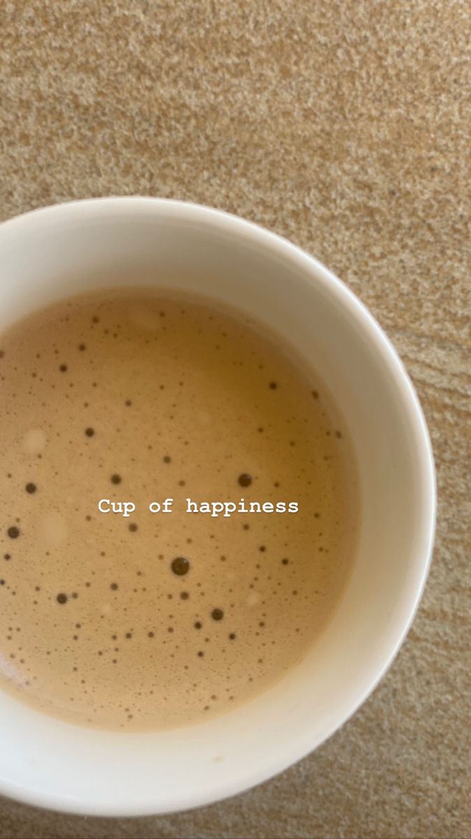 a white cup filled with liquid on top of a table