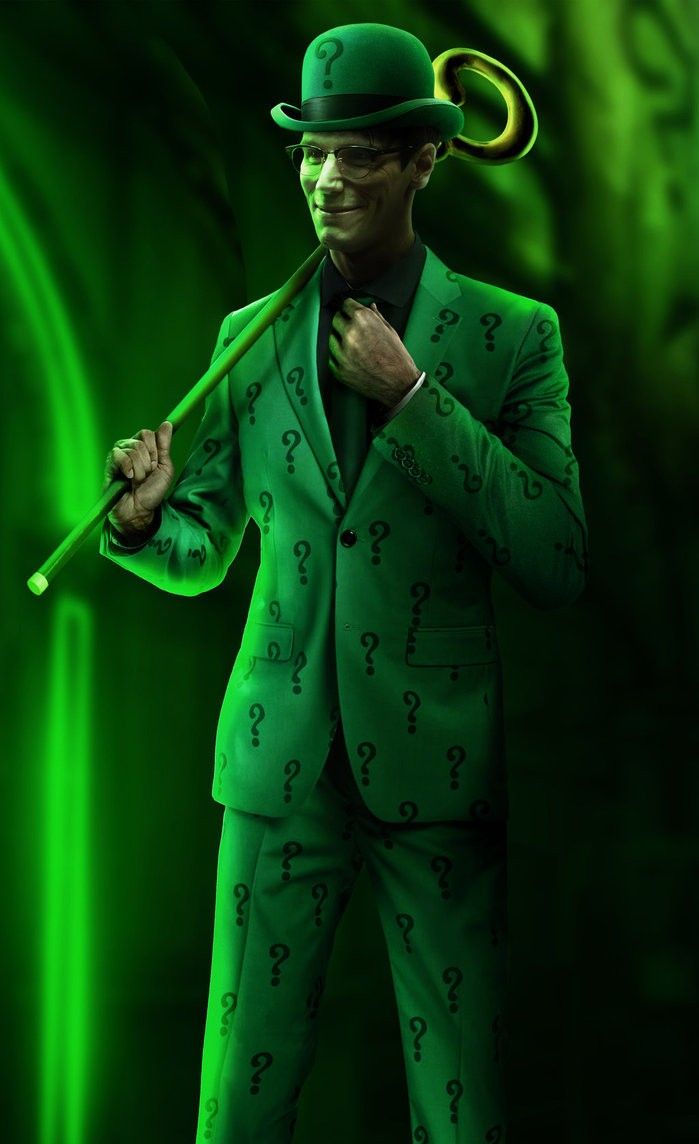 a man in a green suit and top hat holding an umbrella