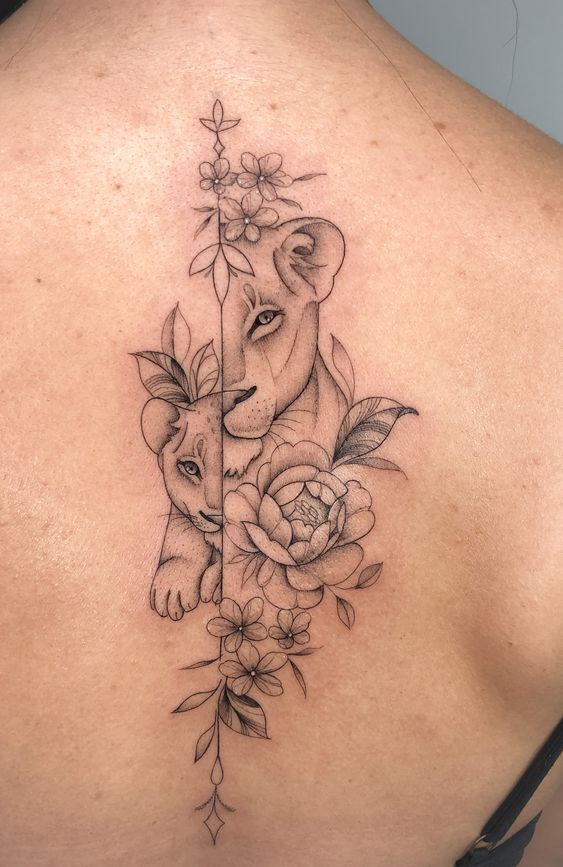 the back of a woman's shoulder with an elephant and roses tattoo on it