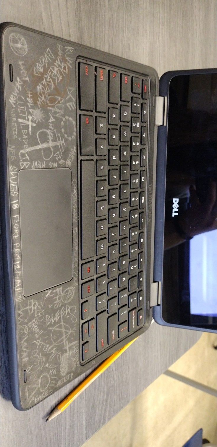 an open laptop computer sitting on top of a wooden table