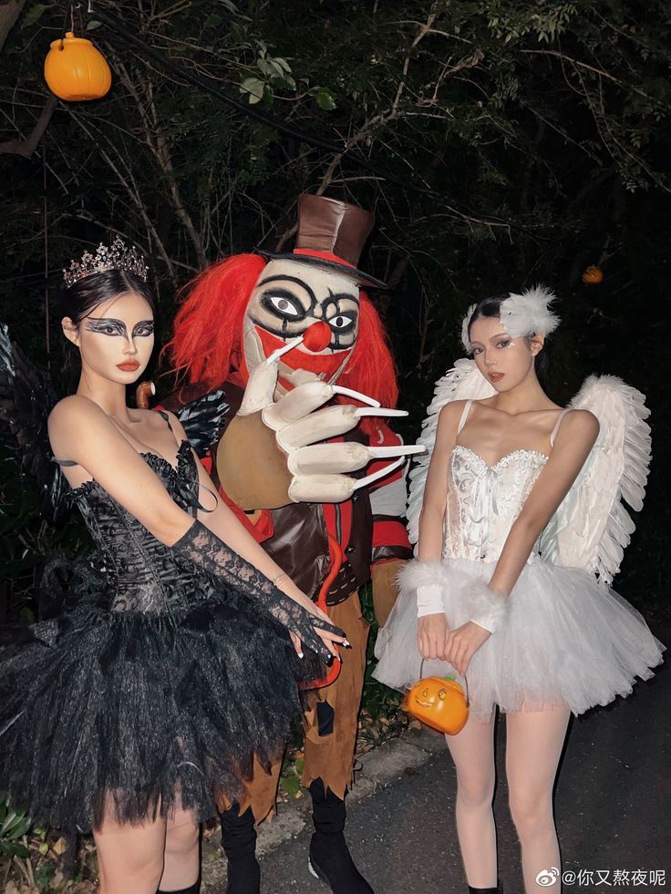 two women in costumes standing next to each other near an orange tree and a man dressed as a nutcracker