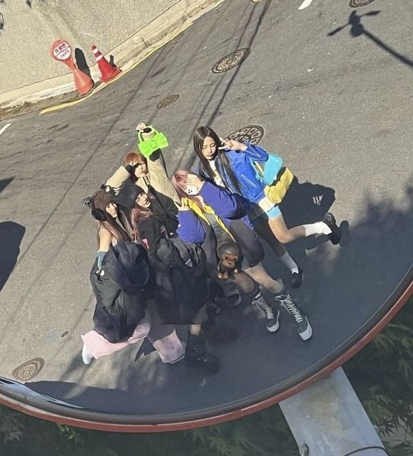 a group of young people standing next to each other on top of a skateboard