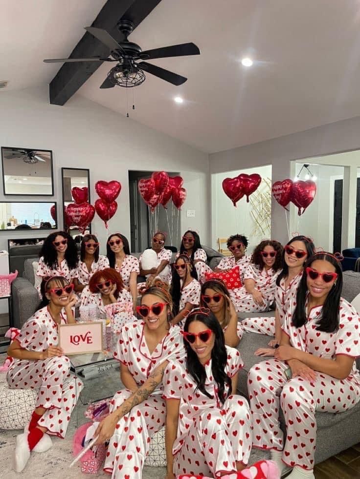 a group of women dressed in red and white polka dot pajamas posing for a photo