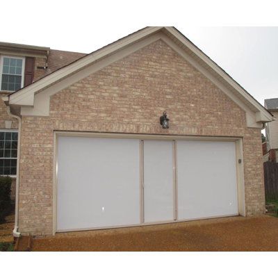 a brick house with two white garage doors