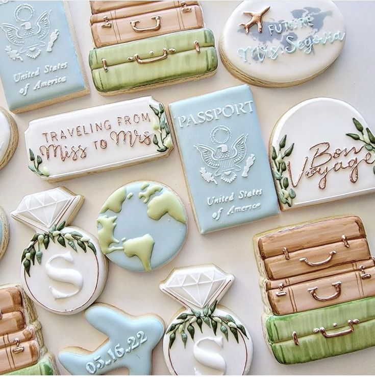 decorated cookies are arranged on a table with travel tags and suitcases in different colors